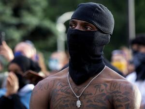 A demonstrator wearing a face mask is seen in Denver, Colorado on May 31, 2020, while protesting the death of George Floyd, an unarmed black man who died while while being arrested and pinned to the ground by the knee of a Minneapolis police officer. Thousands of National Guard troops patrolled major US cities after five consecutive nights of protests over racism and police brutality that boiled over into arson and looting, sending shock waves through the country. The death Monday of an unarmed black man, G