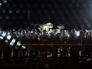 Police officers hold a perimeter behind the metal fence recently erected in front of the White House demonstrators gather to protest the killing of George Floyd on June 2, 2020 in Washington, DC. Anti-racism protests have put several US cities under curfew to suppress rioting, following the death of George Floyd in police custody. Olivier DOULIERY / AFP