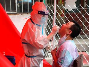 A medical worker takes a swab sample from a resident to be tested for the COVID-19 coronavirus on a street in Mudanjiang, China’s northeastern Heilongjiang province on June 3, 2020. COVID-19 coronavirus testing were made available for free to Heilongjiang province residence starting from June 1, for a week. STR / AFP
