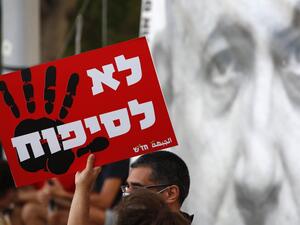 Protesters carry a placard which reads in hebrew "no to annexation" as they gather in Tel Aviv's Rabin Square on June 6, 2020, to denounce Israel's plan to annex parts of the occupied West Bank. Israeli Prime Minister Benjamin Netanyahu has vowed to forge ahead with annexing settlements and the Jordan Valley, in line with the peace proposals unveiled in January by US President Donald Trump. The plan has been angrily rejected by the Palestinians, who say they were not consulted on proposals they see as capit