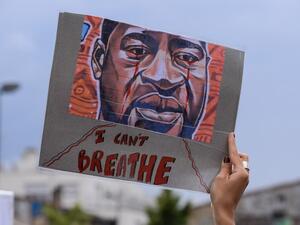 A woman holds a placard depicting George Floyd's face and reading "I can't breathe" in Bordeaux, on June 9, 2020, during a demonstration against racism and police brutality in the wake of the death of George Floyd, an unarmed black man killed while apprehended by police in Minneapolis. NICOLAS TUCAT / AFP