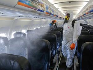 An Israeli worker in full hazmat suit sprays disinfectant in the cabin of an Israir Airlines Airbus A320 airplane, at the Ben Gurion International Airport near the central Israeli city of Tel Aviv, on June 14, 2020, amid the novel coronavirus pandemic. GIL COHEN-MAGEN / AFP