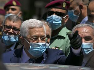 Palestinian President Mahmud Abbas calls on people to wear protective masks as he walks in a street in the West Bank city of Ramallah on June 15, 2020. ABBAS MOMANI / AFP