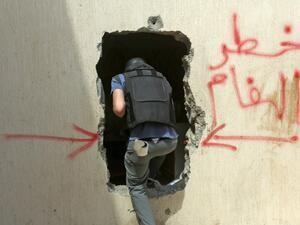 A Turkish deminer enters a house through a hole in the wall with a warning about the presence of mines in the Salah al-Din area, south of the Libyan capital Tripoli, on June 15, 2020. Human Rights Watch earlier this month accused pro-Haftar forces of laying Russian and Soviet-era landmines as they withdrew from Tripoli's southern districts. A team of Turkish deminers arrived in Tripoli last week to bring their expertise, under a broader military cooperation agreement signed late last year between Tripoli an