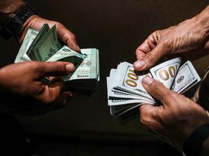 People exchange Lebanese pound and US dollar notes on the black market in Lebanon's capital Beirut on June 18, 2020. JOSEPH EID / AFP