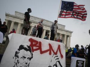 A man waves an American flag with the words "Not Free" painted on it as he takes part in a Juneteenth march and rally in front of the Lincoln Memorial in Washington, DC, on June 19, 2020. ANDREW CABALLERO-REYNOLDS / AFP
