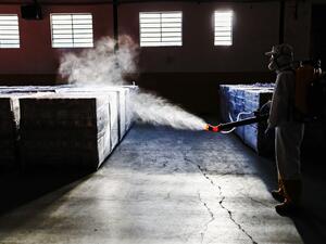 An employee disinfects supplies at a municipal warehouse in Curitiba, Brazil, on June 19, 2020. DANIEL CASTELLANO / AFP