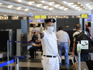 An Egyptian policeman, wearing a protective face shield, signals to passengers at the Sharm el-Sheikh international airport on June 20, 2020. Khaled DESOUKI / AFP