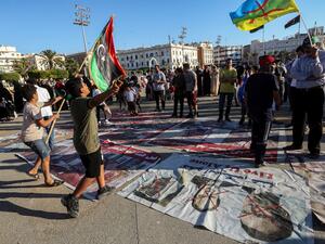 Children wave flags of Libya and the Amazigh as they walk on protest signs showing "X" marks on the faces of (R to L) French President Emmanuel Macron, Egyptian President Abdelfattah el-Sisi, and Abu Dhabi's Crown Prince Sheikh Mohammed bin Zayed Al Nahyan, during a demonstration in the Martyrs' Square. (AFP)
