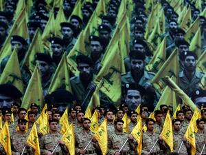 Members of Hezbollah's armed wing stand to attention as hundreds of people gather to watch a televised speech by Hassan Nasrallah on February 22, 2008, in Beirut, Lebanon. [JOSEPH BARRAK/AFP via Getty Images]