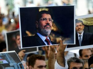 People hold pictures of former Egyptian President Mohamed Morsi during a symbolic funeral ceremony on 18 June in Istanbul (AFP)