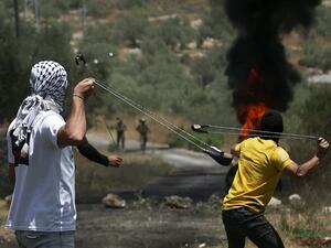 Palestinian protesters use slingshots to hurl stones towards Israeli forces during a demonstration in the village of Kfar Qaddum in the occupied West Bank against the Jewish state's plans to annex part of the Palestinian territory on July 3, 2020. Rival Palestinian factions Fatah and Hamas pledged the previous day a united campaign against Israel's prospective plans to annex territory in the occupied West Bank, in a rare joint press conference, spurred by their common opposition to US President Donald Trump