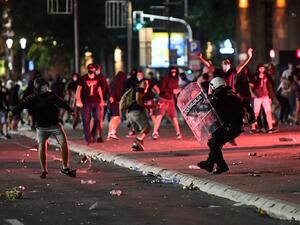 A police officer clashes with protesters near the National Assembly building in Belgrade, on July 10, 2020, during a demonstration against a weekend curfew announced to combat a resurgence of COVID-19 (novel coronavirus) infections. Serbia announced a record coronavirus death toll for a single day on July 10, as the government hit back at protests over its handling of the pandemic. ANDREJ ISAKOVIC / AFP