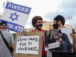 Israelis lift placards during a demonstration in Rabin Square in the central coastal city of Tel Aviv, on July 11, 2020, to protest the government's abandonment of the country's self-employed and other sectors after forcing their businesses to close under COVID-19 regulations, according to the organizers. Jack GUEZ / AFP