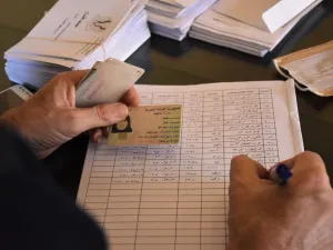 A voting official registers a woman to vote at a polling station in the Nubl neighbourhood of Aleppo on July 19, 2020, during the parliamentary elections. Syrians vote today to elect a new parliament as the Damascus government grapples with international sanctions and a crumbling economy after retaking large parts of the war-torn country. AFP 