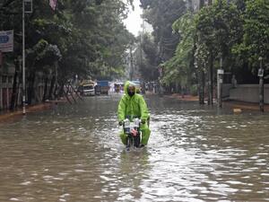 A man rides a bicycle through a water-logged street after a heavy downpour in Dhaka on July 21, 2020. The death toll from heavy monsoon rains across South Asia has climbed to nearly 200, officials said on July 19, as Bangladesh and Nepal warned that rising waters would bring further flooding. Munir Uz zaman / AFP