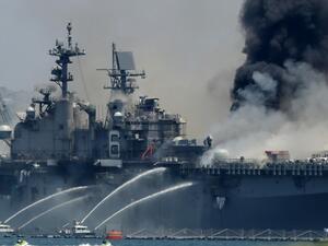 A fire burns on the amphibious assault ship USS Bonhomme Richard at Naval Base San Diego on July 12, 2020 in San Diego, California. There was an explosion on board the ship with multiple injuries reported. Sean M. Haffey/Getty Images/AFP Sean M. Haffey / GETTY IMAGES NORTH AMERICA / Getty Images via AFP