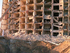In this file photo taken on 27 June, military personnel survey the damage to Khobar Towers caused by the 25 June explosion of a fuel truck outside the northern fence of the facility on King Abdul Aziz Air Base near Dhahran, Saudi Arabia. (AFP)