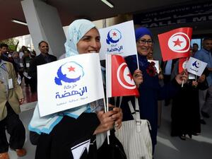 A file photo shows supporters of Tunisia's Islamist Ennahdha Party wave the national flag and the party flag during the opening of Ennahdha in Tunis. (AFP)