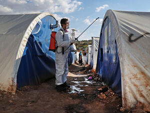 A member of the Syrian relief group Violet Organization disinfects tents at a camp for displaced people north of Idlib, Syria, on March 21. OMAR HAJ KADOUR/AFP VIA GETTY IMAGES