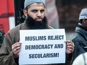 London, UK - 24 January 2014: a protester holds a placard reading "Muslims reject democracy and secularism!" outside the Regents Park Mosque  (Shutterstock)