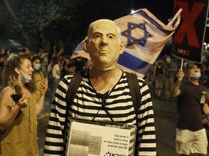 A protester, wearing a mask of Israeli Prime Minister Benjamin Netanyahu, takes part in ongoing anti-government demonstrations in Jerusalem on July 30, 2020. Protests have grown against the veteran premier over his handling of the coronavirus pandemic and the devastating economic crisis it has caused. The prime minister has been accused of leading a chaotic virus containment strategy as cases have surged and economically painful initial restrictions have been reimposed.  Ahmad GHARABLI / AFP