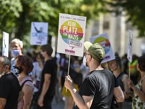 A counter-protester holds a sign reading "No place for Nazis" during a demonstration by the initiative "Querdenken-711" with the slogan "the end of the pandemic-the day of freedom" to protest against the current measurements to curb the COVID-19 spreading in Berlin, on August 1, 2020. John MACDOUGALL / AFP