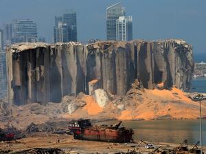 A picture taken on August 5, 2020 shows the damaged grain silo and a burnt boat at Beirut's harbour, one day after a powerful twin explosion tore through Lebanon's capital, resulting from the ignition of a huge depot of ammonium nitrate at the city's main port. STR / AFP