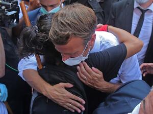 A Lebanese youth hugs French President Emmanuel Macron during a visit to the Gemmayzeh neighbourhood, which has suffered extensive damage due to a massive explosion in the Lebanese capital, on August 6, 2020. French President Emmanuel Macron visited shell-shocked Beirut, pledging support and urging change after a massive explosion devastated the Lebanese capital in a disaster that has sparked grief and fury. AFP
