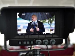 Belarus' President Alexander Lukashenko is seen on a screen while speaking to the media outside a polling station after casting his ballot in the presidential election in Minsk on August 9, 2020. Sergei GAPON / AFP