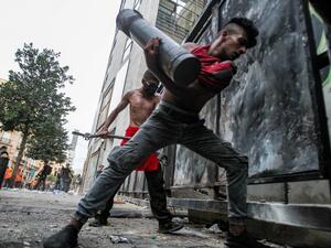 Lebanese protesters try to break through a barrier amid clashes with security forces in the vicinity of the parliament building in the centre of Beirut on August 11, 2020, following a huge explosion that devastated large parts of the capital. IBRAHIM AMRO / AFP