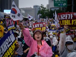 Members of pro-US conservative right-wing and religious christian groups wave flags and shout slogans during an anti-government rally in the central Gwanghwamun area of Seoul on August 15, 2020. (AFP)