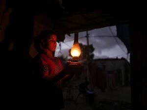 A Palestinian girl uses a gas lamp during a power cut after Gaza's sole power plant shut down amid tension with Israel, in an impoverished household in Khan Yunis in the southern Gaza Strip, on August 18, 2020. MAHMUD HAMS / AFP