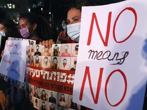 Israeli protesters, wearing protective masks due to the COVID-19 pandemic, hold placards as they take part in a demonstration in Tel Aviv on August 23, 2020, to denounce sexual violence against women. JACK GUEZ / AFP