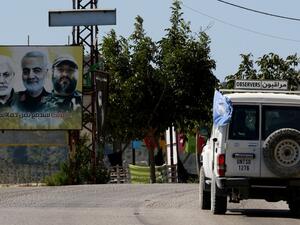 A UNIFIL patrol drives past a billboard showing the faces of slain (L ro R) Iraqi Hashed al-Shaabi (Popular Mobilisation) forces commander Abu Mahdi al-Muhandis, Iranian Quds Force commander Qasem Soleimani, and Hezbollah commander Imad Mughniyeh, in the southern Lebanese village of Adaisseh on the border with Israel on August 26, 2020. (AFP)