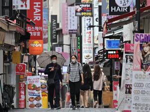 People walk through the Myeongdong shopping district in Seoul on August 27, 2020. South Korea's central bank slashed its growth forecast on August 27, predicting the world's 12th-largest economy will shrink more than one percent this year as it braces for a surge of coronavirus infections. Jung Yeon-je / AFP