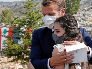 French President Emmanuel Macron hugs a blast victim while attending a ceremony to mark Lebanon's centenary in Jaj Cedars Reserve Forest, northeast of the capital Beirut, on September 1, 2020. GONZALO FUENTES / POOL / AFP