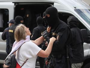 A woman talks to a riot police officer as students protest against presidential elections results in Minsk on September 1, 2020. TUT.BY / AFP