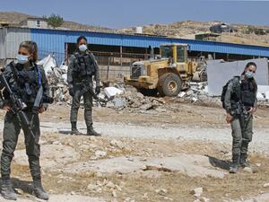 Israeli security forces guard a bulldozer demolishing a Palestinian house and shack in the southern West Bank village of Khirbet Jinba on September 1, 2020. (AFP)