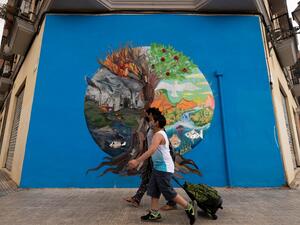 A mother escorts her child to school on the first day of classes for the new academic year in Valencia on September 7, 2020 amid the coronavirus pandemic. Spain will require all students aged six or older to wear masks and is urging them to wash their hands at least five times a day. JOSE JORDAN / AFP