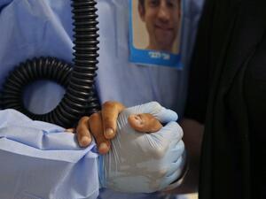 A medical worker holds a patient's hand during physiotherapy to help with oxygen circulation at the COVID-19 isolation ward of Meir Medical Center in Kfar Saba, near the Israeli coastal city of Tel Aviv, on September 9, 2020. GIL COHEN-MAGEN / AFP