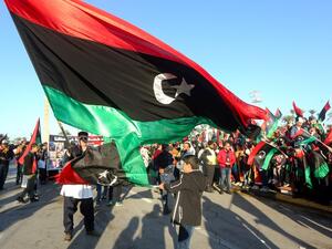 In this file photo taken on February 17, 2020, Libyans wave the national flag as they commemorate the ninth anniversary of the uprising against former Libyan leader Moamer Kadhafi, in Tripoli on February 17, 2020. Mahmud TURKIA / AFP
