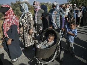 Refugees and migrants wait for a food distribution at a road where thousands are living with out shelter, near the Kara Tepe camp on the island of Lesbos on September 13, 2020. Over 11,000 people -- including some 4,000 children -- have been sleeping rough since the notoriously overcrowded and unsanitary camp of Moria burned down this week..Aided by army bulldozers, work crews have worked round-the-clock to erect a makeshift camp for 3,000 people a few kilometres from the ruins of Moria where the first 500 