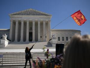 A woman waves an 'RBG' flag outside the US Supreme Court at a makeshift memorial for late US Supreme Court Justice Ruth Bader Ginsburg is seen near the steps of the US Supreme Court on September 21, 2020 in Washington, DC. (AFP)