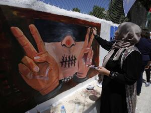 Palestinian women paint murals as they mark Palestinian Prisoner Day in the West Bank city of Ramallah on 17 April 2016 (AFP)