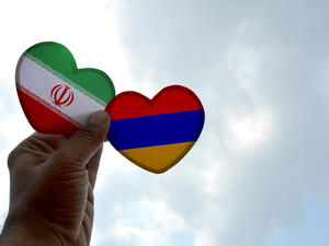 Hand holds a heart Shape Iran and Armenia flag, love between two countries  (Shutterstock)