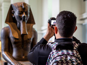 A tourist taking photo of an egyptian status brought from Egypt and kept in British Museum of London (Shutterstock/ File Photo)