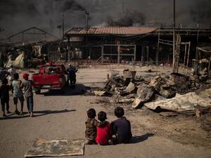 Children sit on the ground in the burnt camp of Moria on the island of Lesbos after a major fire broke out, on September 9, 2020. (AFP/File Photo)