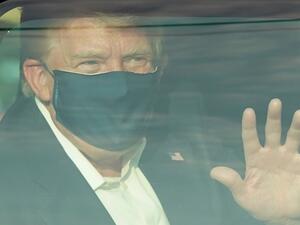 A car with US President Trump drives past supporters in a motorcade outside of Walter Reed Medical Center in Bethesda, Maryland on October 4, 2020. US President Donald Trump drove past supporters outside the hospital where he was being treated for Covid-19, after announcing on Twitter a "suprise visit" to his backers. ALEX EDELMAN / AFP