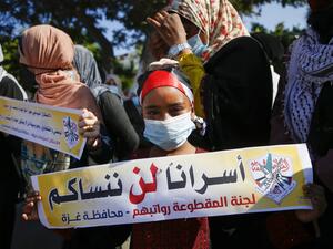 A Palestinian girl, wearing a protective face mask, takes part in a demonstration to how their support to prisoners held in Israeli jails, in Gaza City on October 5, 2020. MOHAMMED ABED / AFP